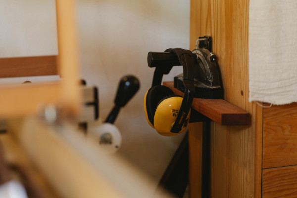 yellow safety headphones hanging on a hook.